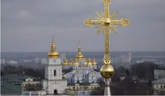  ?? ?? Une croix restaurée de la cathédrale Sainte-Sophie est visible devant le monastère à dôme d'or de Saint-Michel à Kiev, en Ukraine, le jeudi 21 décembre 2023.