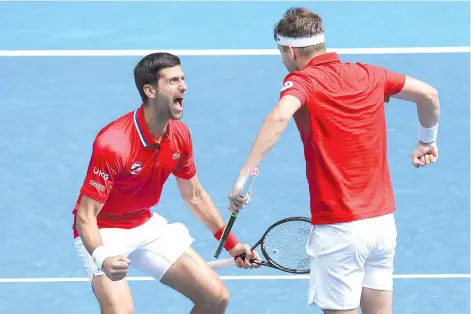  ??  ?? Djokovic (left) celebrates with teammate Filip Krajinovic after winning against Canada's Milos Raonic and Denis Shapovalov.