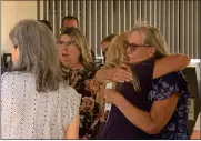  ?? Caleb Lunetta/The Signal ?? Family members embrace outside the courthouse after James “Matthew” Dorsey is sentenced for the murder of his estranged wife, Michelle Dorsey.