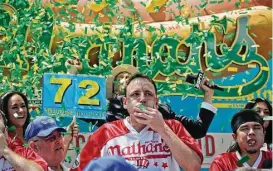  ?? Bebeto Matthews photos / Associated Press ?? Joey “Jaws” Chestnut claimed his 10th victory at the annual Nathan’s Famous July Fourth hot dog eating contest in the Brooklyn borough of New York on Tuesday. He gobbled down 72 hot dogs and buns in 10 minutes, topping his own record last year.