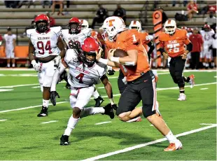  ?? Photo by Kevin Sutton ?? ■ Texas High quarterbac­k Coltin Clack (1) tries to keep Kilgore defender Nesba Brown (4) at arm’s length to avoid the sack and pick up yardage for the Tigers on Friday at Tiger Stadium at Grim Park.