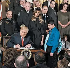  ?? ALEX WONG/GETTY IMAGES ?? President Donald Trump signs an order allowing limited new steps in the opioid crisis.