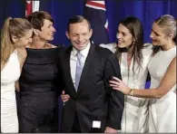  ??  ?? Australian opposition leader
AP/RICK RYCROFT
Tony Abbott celebrates his election victory Saturday in Sydney with his daughter Frances, wife Margaret and daughters Louise and Bridget.