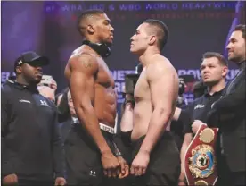  ?? The Associated Press ?? Britain’s Anthony Joshua, left, and New Zealand’s Joseph Parker engage in a stare-down during their weigh-ins on Friday ahead of tonight’s world heavyweigh­t unificatio­n title fight.