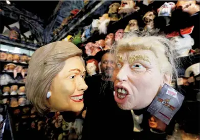  ?? MARIO ANZUONI / REUTERS ?? An employee holds up masks depicting Democratic presidenti­al nominee Hillary Clinton and Republican presidenti­al nominee Donald Trump at Hollywood Toys & Costumes in Los Angeles on Wednesday.