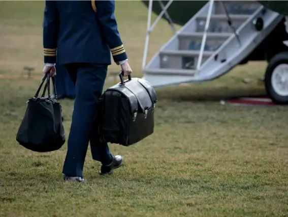  ??  ?? A military aide carries the ‘football’ – a case with the launch codes for nuclear weapons (Getty)