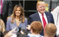  ?? ALEX EDELMAN / GETTY IMAGES ?? President Donald Trump and first lady Melania Trump walk on the South Lawn of the White House on Wednesday prior to greeting guests during a picnic for military families.