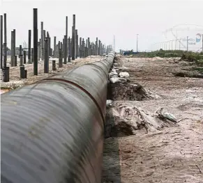  ??  ?? Rapid pipe: An oil pipeline is laid next to the Vopak-Dialog oil storage facility and a Rapid project constructi­on site in Pangerang, Johor. – Reuters