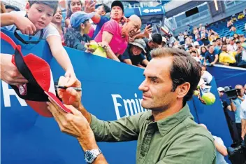  ?? — AFP ?? Roger Federer obliges autograph hunters during a training session ahead of the US Open.
