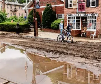  ?? Allyse Pulliam/special to the Times Union ?? New York announced a $3 million program to make grants available to certain homeowners in eight counties where flooding caused major damage last month. Above, Highland Falls residents walk down a mud-covered Main Street after flash floods on July 9.