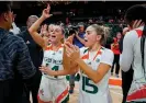  ?? Photograph: Miami Herald/ ?? Miami’s Haley Cavinder (14) and Hanna Cavinder (15) celebrate after the Hurricanes defeated Florida State at the Watsco Center in February.