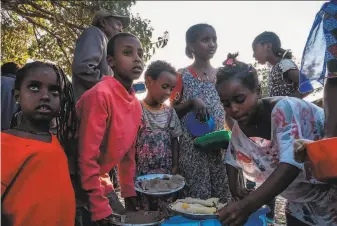  ?? Eduardo Soteras / AFP via Getty Images ?? Children displaced by fighting in the Tigray region of Ethiopia gather to receive food aid at the school where they are sheltering in Tigray’s capital of Mekele on Wednesday.