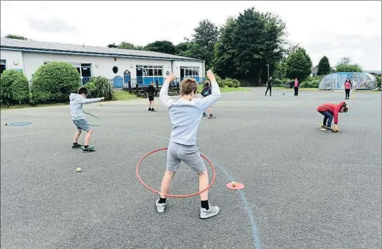  ?? REBECCA NADEN / REUTERS ?? Los profesores de una escuela en Tenby, Gales, explican a los alumnos las normas de distancia social en su reapertura el pasado 29 de junio