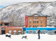  ?? Kelsey Brunner, The Aspen Times ?? A banner promoting the Aspen Mountain Film Festival hangs on the side of the historic Wheeler Opera House as dogs play nearby.