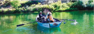  ??  ?? K.C. Henthorn, front of boat in wheelchair, fishing guide Chris Gallegos, in middle with oars, and GO Unlimited founder Dustin Berg on a drift-fishing trip in June on the San Juan River.