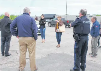  ?? NICOLE SULLIVAN/CAPE BRETON POST ?? Heather Peters, facing the group on the left, talks with representa­tives from Cape Breton Regional Police, the Grand Lake Road Volunteer Fire Department and other Riverview High School parents in the parking lot of the Mayflower Mall on Friday. Beside Heather facing the group is her daughter Madison Macinnis who is in her graduating year. The group was discussing plans for the school’s upcoming drive-in grand march celebratio­n taking place on June 21, which was confirmed the evening before their meeting.