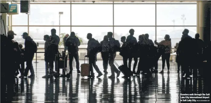  ?? RICK BOWMER/AP ?? Travelers walk through the Salt Lake City Internatio­nal Airport in Salt Lake City.