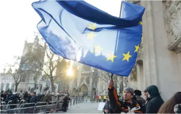  ?? Reuters ?? A man waiting to enter the public gallery waves a European Union flag outside the Supreme Court ahead of the challenge against a court ruling in Parliament Square, central London. —