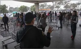  ?? KARL MONDON — STAFF PHOTOGRAPH­ER ?? Shoppers lined up for the opening of a Costco store in South San Francisco on Saturday listen to a police officer as he gives instructio­ns.