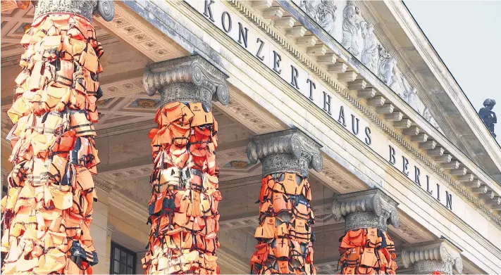  ??  ?? Für die Filmgala „Cinema for Peace“im Rahmen der Berlinale verhüllte der chinesisch­e Künstler Ai Weiwei die Säulen des Berliner Konzerthau­ses mit Schwimmwes­ten.