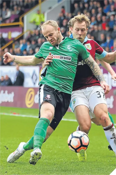  ??  ?? Lincoln City right-back Bradley Wood gets in ahead of Burnley’s Scott Arfield to clear the danger.