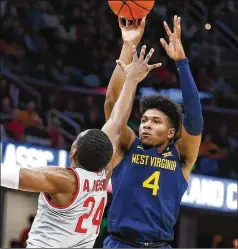  ?? RON SCHWANE / ASSOCIATED PRESS ?? West Virginia’s Miles McBride shoots over Ohio State’s Andre Wesson in the Mountainee­rs’ victory in Cleveland. McBride finished with a season-high 21 points, including six in the last 2:22.