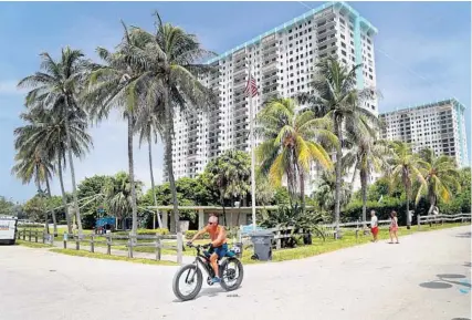  ?? SUSAN STOCKER/SOUTH FLORIDA SUN SENTINEL ?? A bicyclist rides by Harry Berry Park in Hollywood on Monday, where a new beachfront luxury condo might be built on public land. The land at 1301 S. Ocean Drive is currently valued at $35 million.