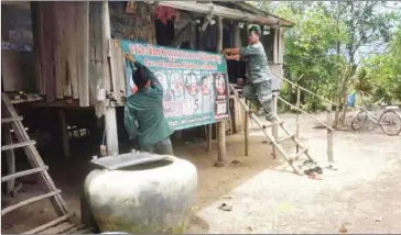  ?? SUPPLIED ?? Sre Ambel district police officials tear down a banner calling for the release of the ‘Adhoc 5’ last week, claiming that the display ‘affects peace and security’.