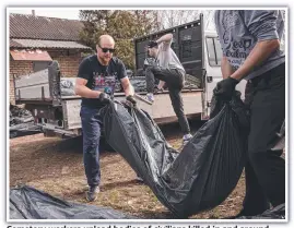  ?? ?? Cemetery workers unload bodies of civilians killed in and around Bucha, Ukraine.