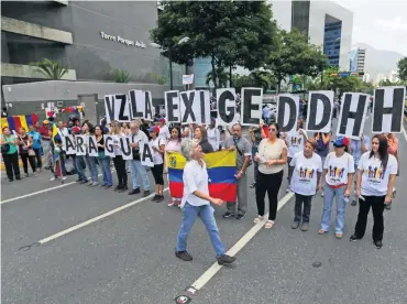  ?? ?? Partidario­s de la oposición con el lema: “Venezuela exige derechos humanos”, en Caracas en 2019.