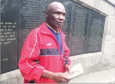  ??  ?? Ali Mwadama, a survivor of the 1998 US Embassy bombing, looks for the names of his friends on the August 7th memorial wall in Nairobi, Kenya