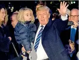  ?? — AFP ?? US President Donald Trump waves to the media as he holds his granddaugh­ter, Chloe Sophia Trump, after his arrival in Washington on Sunday.