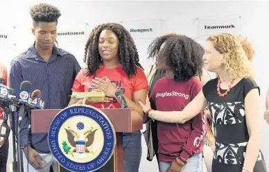  ?? TAIMY ALVAREZ/STAFF PHOTOGRAPH­ER ?? Marjory Stoneman Douglas junior and gun-safety advocate Mei-Ling Ho-Shing pauses as she speaks about gun control. Students Brandon Sadent, left, and Tyah Amoy-Roberts, right, along with U.S. Rep. Debbie Wasserman Schultz, D-Weston, lend support.