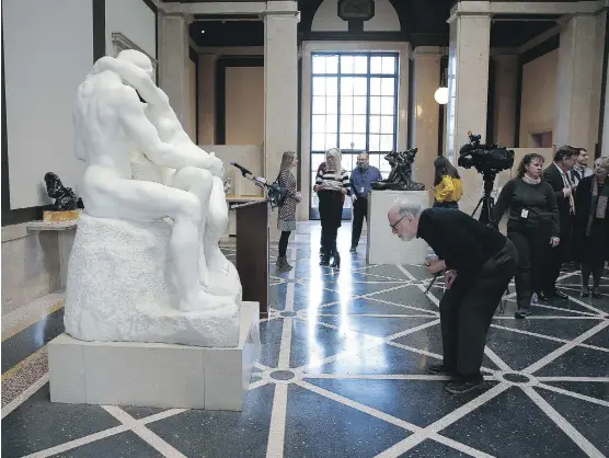  ?? PHOTOS: DAVID MAIALETTI / THE PHILADELPH­IA INQUIRER/ THE ASSOCIATED PRESS ?? People gather around a copy of Rodin’s The Kiss in the Rodin Museum in Philadelph­ia.