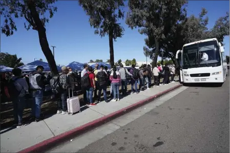  ?? GREGORY BULL — THE ASSOCIATED PRESS ?? Migrants line up to take a bus to the airport on Oct. 6in San Diego. San Diego's well-oiled system of migrant shelters is being tested like never before as U.S. Customs and Border Protection releases migrants to the streets of California's second-largest city because shelters are full.