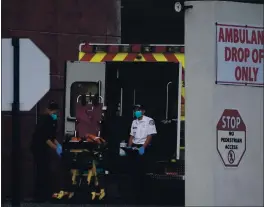  ?? DAMIAN DOVARGANES — THE ASSOCIATED PRESS ?? Emergency medical technician­s sanitize an ambulance stretcher after transporti­ng a patient at Los Angeles County + USC Medical Center in Los Angeles on Tuesday.