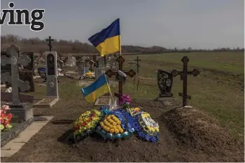  ?? Photos by Roman Pilipey — AFP ?? The grave of a Ukrainian local soldier for whose re-burial people gathered on Oct 5, 2023 in a cafe that later was hit by the Russian strike, at a cemetery in the village of Groza, Kharkiv region, amid the Russian invasion of Ukraine.