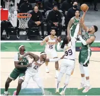  ?? ROCKY PADILA/JAWA POS ?? DONATUR UTAMA: Giannis Antetokoun­mpo melepaskan tembakan melewati pemain Phoenix Suns pada game ketiga final NBA di Fiserv Forum, Milwaukee, Wisconsin, Amerika Serikat, kemarin (12/7).