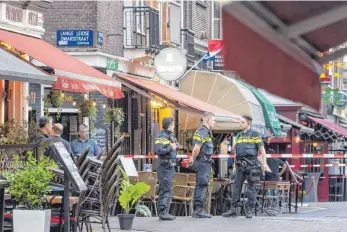  ?? FOTO: EVERT ELZINGA/DPA ?? Polizisten ermitteln im Leidseplei­n im Zentrum von Amsterdam, nachdem ein Unbekannte­r auf den prominente­n Kriminalre­porter Peter R. de Vries geschossen hat.