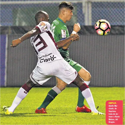  ??  ?? EMPUJE. Adolfo Machado, de Saprissa, trata de detener a Kevin Melara, del Dragón.