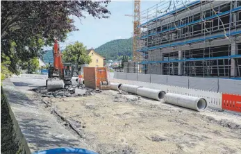  ?? FOTOS: ALEXANDRA SCHNEID ?? Die Schlossstr­aße in Rietheim-Weilheim wird derzeit saniert (linkes Bild). Rechts im Bild ist der Bau des neuen Entwicklun­gs- und Innovation­szentrums des Automobilz­ulieferers Marquardt zu sehen. In der Straße Schmidten (rechtes Bild) werden Leitungen, beispielsw­eise für Wasser, Abwasser und Breitband, verlegt.