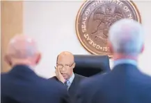  ??  ?? Paul Krebs, right, stands beside his lawyer, Paul Kennedy, at a hearing Monday before state District Court Chief Judge Stan Whitaker, center.