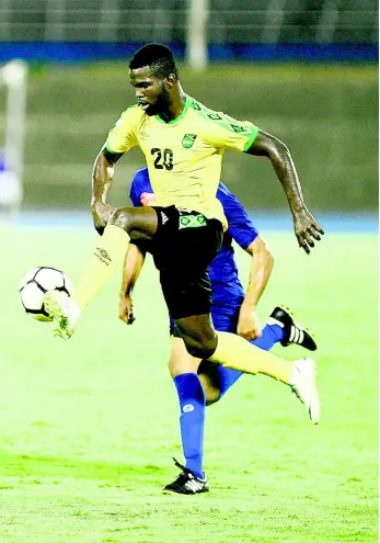  ?? FILE ?? Jamaica’s Kemar Lawrence (foreground) takes the ball under control while being chased by Cayman Islands defender Kyle Santamaria during their CONCACAF Nations League game at the National Stadium on Sunday, September 9, 2018.