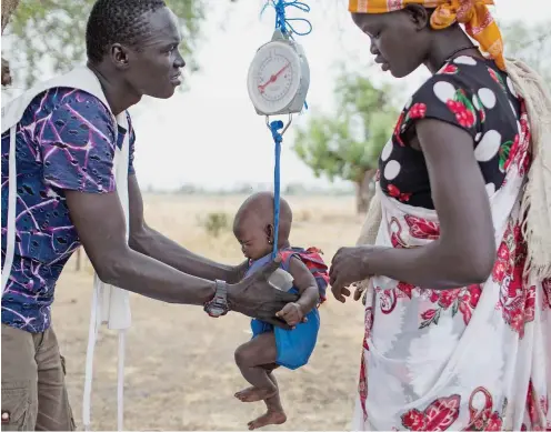  ?? Foto: dpa/Siegfried Mod ?? In einem Hilfszentr­um in Südsudan wird ein Kind gewogen.