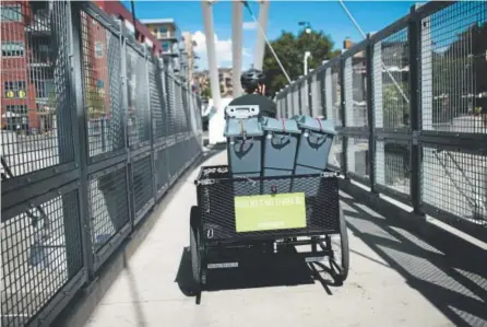  ?? Gabriel Scarlett, The Denver Post ?? Joel Cruz, an intern for Scraps, a small-scale, bike-based composting company, pedals around the streets of Denver last month. He was collecting compost from some of Scraps’ clients.