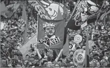  ?? AFP ?? Leverkusen fans celebrate on the pitch with a banner of "King Xabi" following Sunday’s 5-0 win over Werder Bremen.