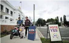  ?? /Reuters ?? Yay or nay: Voters walk past Vote Yes and Vote No signs at the Old Australian Parliament House during The Voice referendum, in Canberra, Australia, in October 2023.