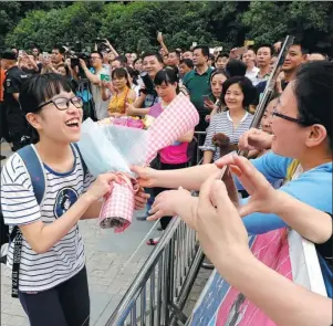  ?? CHEN SANHU / FOR CHINA DAILY ?? A student receives flowers after taking the gaokao last year.