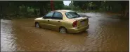  ?? (AP/Carlos Giusti) ?? A car sits in floodwater­s Saturday caused by Tropical Storm Laura in Salinas, Puerto Rico.