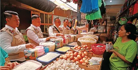  ?? HARIYANTO TENG/ JAWA POS ?? PANTAU BAHAN POKOK: Kompol Ernesto (dua dari kiri) bersama Satgas Pangan Polda Jawa Timur saat sidak di Pasar Pabean kemarin (30/12).